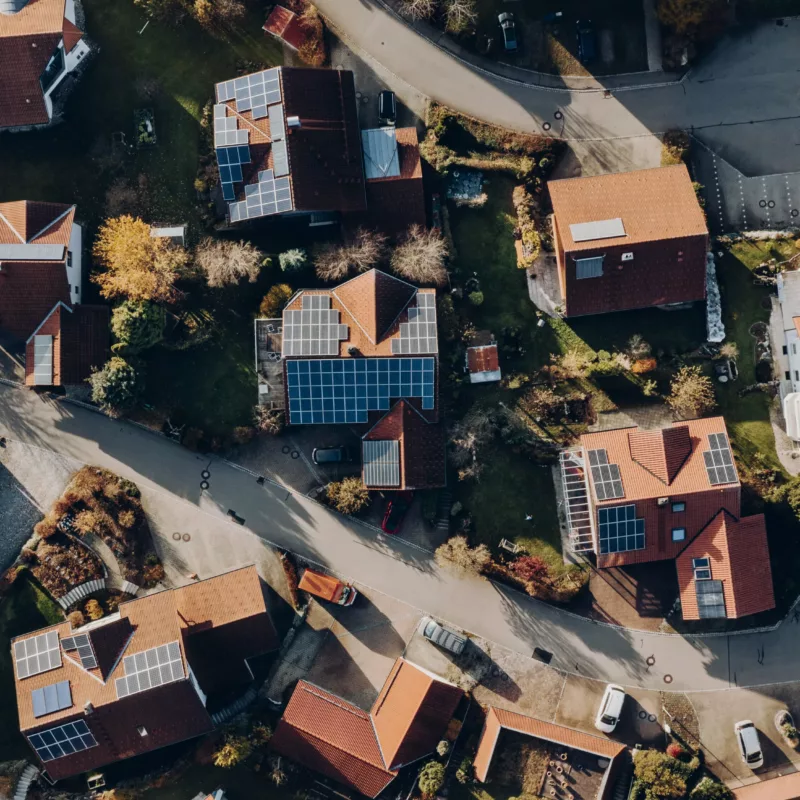 Referenzen Wohnsiedlung – Haus der Energie Luftaufnahme einer Wohnsiedlung mit Photovoltaik-Referenzen – Haus der Energie