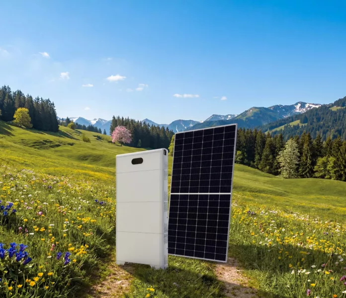 Haus der Energie Photovoltaikpanel mit Batteriespeicher in blühender Frühjahrslandschaft.