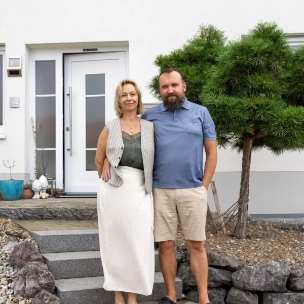 Ehepaar vor ihrem Haus mit Photovoltaik von Haus der Energie